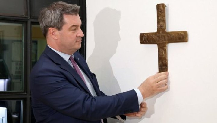 Маркус Зедер, премьер-министр Баварии, вешает крест у входа в государственную канцелярию в Мюнхене