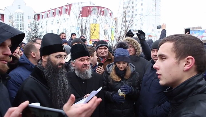 Участник акции «Переходь до Православної Церкви України» общается с клириками и мирянами УПЦ