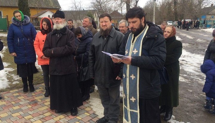 Верующие Украинской Православной Церкви совершают молитвенное стояние и читают акафист под стенами Свято-Покровской церкви в Мнишине.