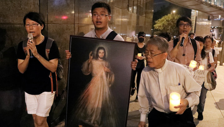 Католический священник вместе с прихожанами участвует в акции протеста в Гонконге. Фото: uca.news