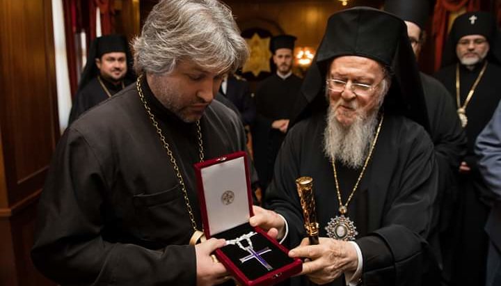 Ο Ντεντιούχιν λαμβάνει δώρο σταυρό από τον Πατριάρχη Βαρθολομαίο. Φωτογραφία: Facebook