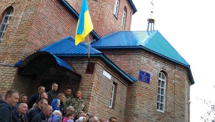 OCU activists on the steps of the Holy Dormition Church of the UOC in vlg. Gvardeiskoye. A photo: spzh.news/ru