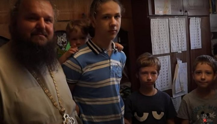Archpriest John Serediuk handed over the aid gathered by parishioners to a large family from Kyiv. Photo: screenshot of YouTube video/ “1Kozak” channel.