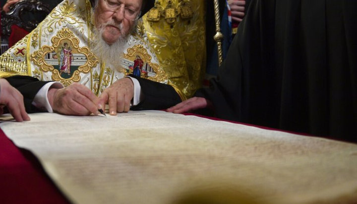 Патриарх Варфоломей подписывает томос. Фото: Укрправда