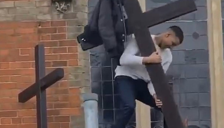 Молодий вандал у Лондоні скидає хрест з церкви. Фото: dailymail.co.uk