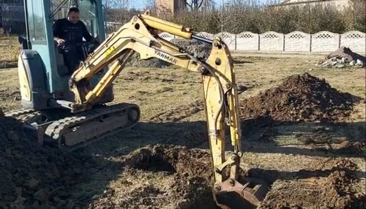 Construction equipment is working on the land plot where the new UOC church is being built. Photo: a video screenshot from the Facebook page of the UOC community in Horoshivtsi