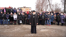 Believers of UOC hold a prayer standing at Khotyn mayor's office