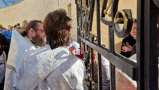 Lavra believers take communion through the bars today