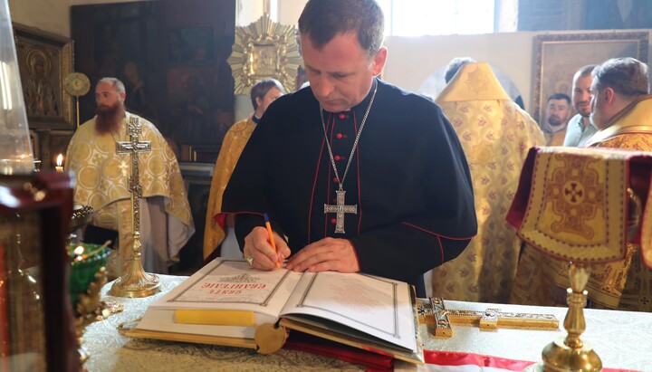 Католический епископ Павел Гончарук расписывается в Евангелии на престоле храма ПЦУ. Фото: Фейсбук Драбинко