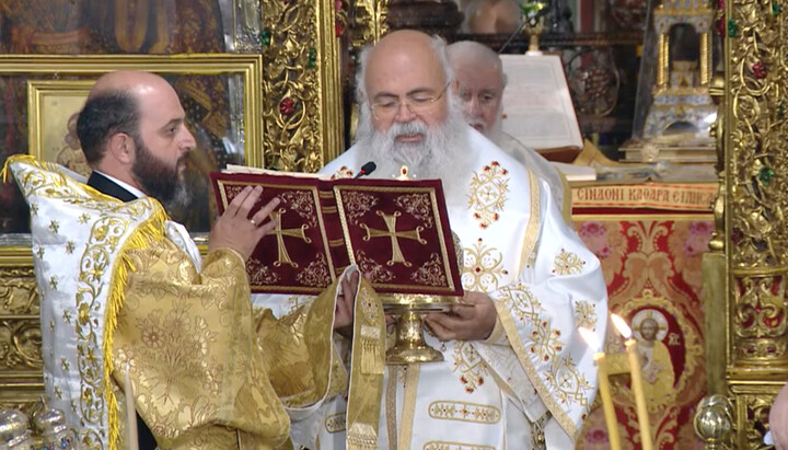 Ο Αρχιεπίσκοπος Κύπρου κ. Γεώργιος διαβάζει δίπτυχο. Πίσω του βρίσκεται ο Μητροπολίτης Κύκκου Νικηφόρος. Φωτογραφία: στιγμιότυπο του καναλιού YouTube Ι. Μ. Κύκκου