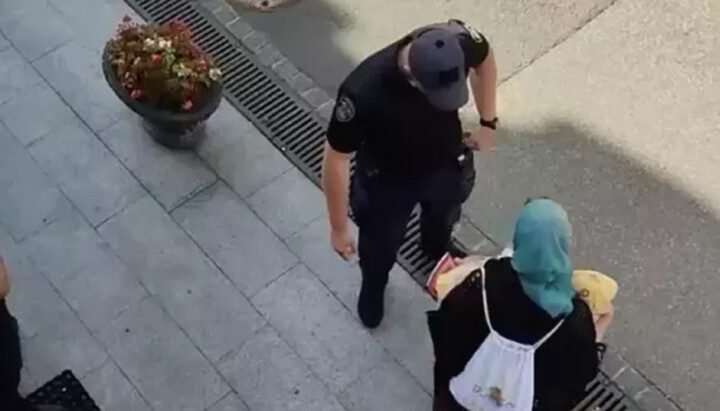 Поліцейський не дає передавати хліб захисникам Лаври. Фото: скріншот відео t.me/nikita_chekman