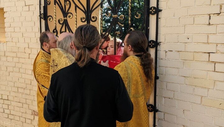 Lavra parishioners had to receive communion through the gate with bars. Photo: UOJ