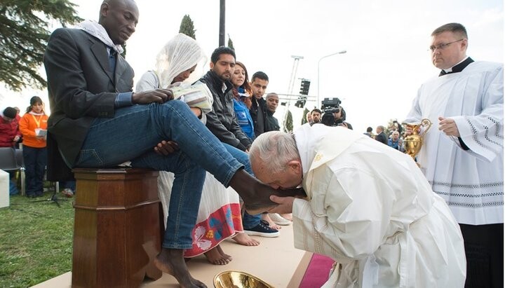 Папа римский Франциск целует ноги мигранту. Фото: epaimages.com