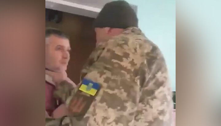 Man in military uniform choking UGCC cleric. Photo: screenshot from the video on the Politika Strany Telegram channel
