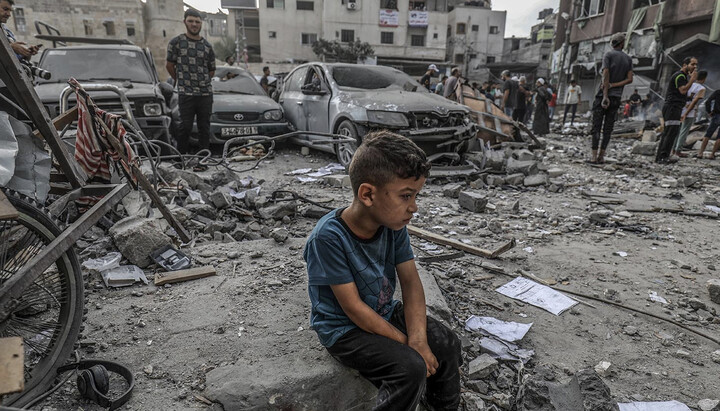 Мальчик на руинах своего дома в секторе Газа. Фото: forbes.ru