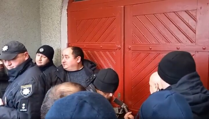 Raiders breaking the door of the UOC temple in the village of Rzhavintsy. Photo: a video screenshot from the Facebook page of the Chernivtsi-Bukovyna Eparchy
