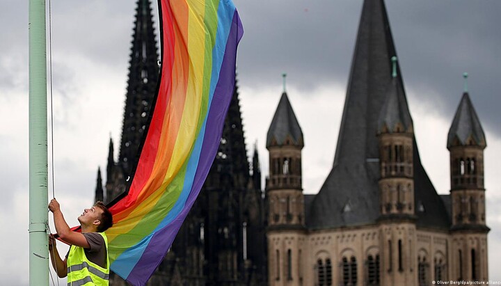 Прапор ЛГБТ на тлі католицького собору. Фото: DW