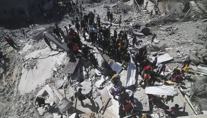 Οι Παλαιστίνιοι κοιτάζουν πολυκατοικία που καταστράφηκε από τις ισραηλινές δυνάμεις στη Ράφα, στη Λωρίδα της Γάζας, 20 Μαρτίου 2024. Φωτογραφία: cruxnow.com
