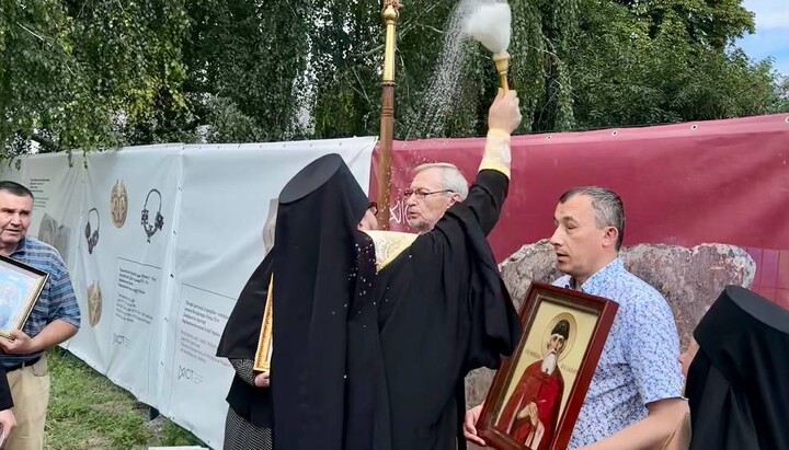 Bishop Kliment blesses the site of the destroyed church through the fence. Photo: Desiatynnyi Monastery